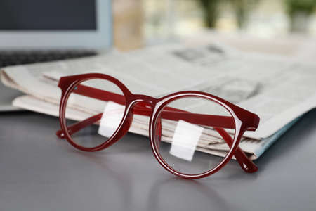 Newspapers and glasses on gray table, closeupの写真素材