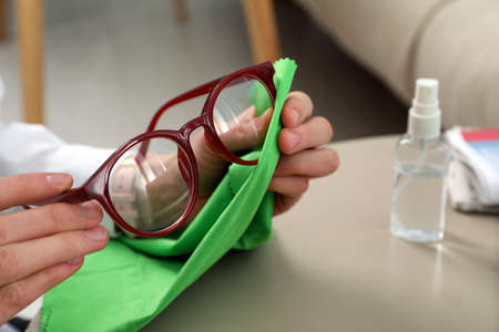 Woman cleaning glasses with microfiber cloth at home, closeupの写真素材