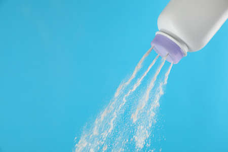 Scattering of dusting powder on light blue background, space for textの写真素材