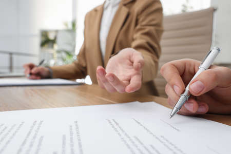 Businesspeople signing contract at table in office, closeupの写真素材