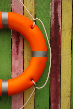 Orange lifebuoy hanging on wooden fence. Rescue equipmentの写真素材