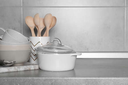 Cooking utensils and other kitchenware on gray countertop. Space for text