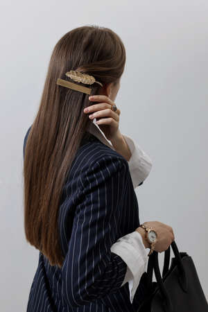 Young woman with beautiful hair clips on light background, back viewの写真素材