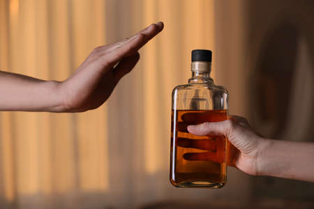 Man refusing to drink whiskey indoors, closeup. alcohol treatment addiction