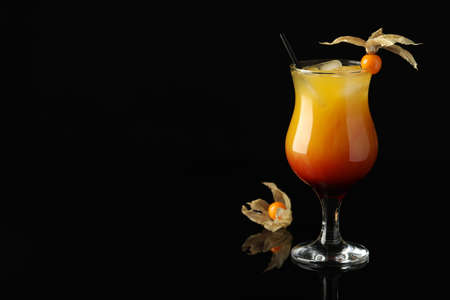 Tasty cocktail decorated with physalis fruit on black background. Space for textの写真素材