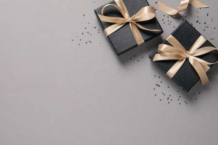 Beautiful gift boxes and confetti on gray background, flat lay. Space for textの写真素材