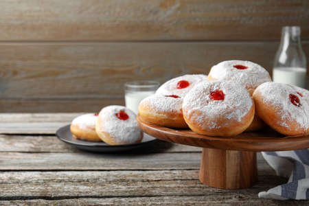 Pastry stand with delicious jelly donuts on wooden table. Space for textの写真素材