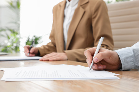 Man signing contract at table in office, closeup.の写真素材