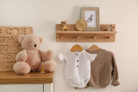 Wooden shelf with baby clothes, toys and furniture in the room. interior designの写真素材