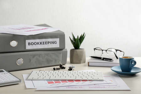 Bookkeeper's workplace with folders and documents on table