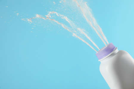 Scattering of dusting powder on light blue background, space for textの写真素材