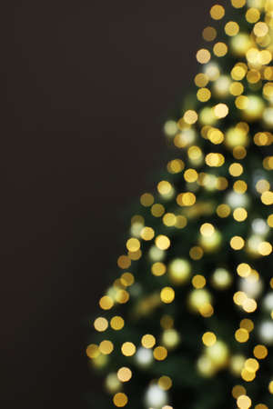 Blurred view of beautifully decorated Christmas tree on brown background