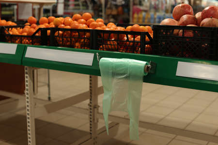 Plastic bags near crates with fruits in supermarketの写真素材