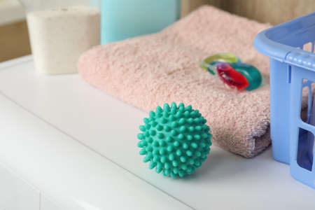 Turquoise dryer ball, detergents and towels on washing machineの写真素材