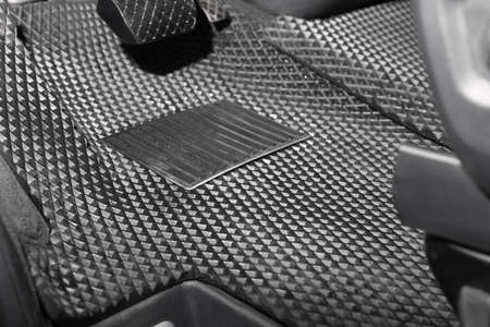 Black rubber car floor mat in auto, closeup
