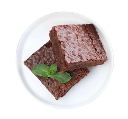 Pieces of delicious chocolate brownie with fresh mint on white background, top viewの写真素材