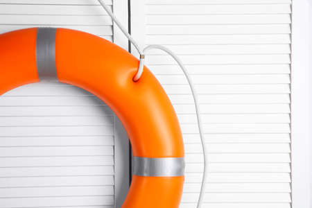 Orange lifebuoy on white wooden background, space for text. Rescue equipmentの写真素材