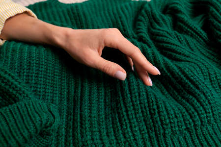 Woman touching soft green knitted sweater, closeupの写真素材