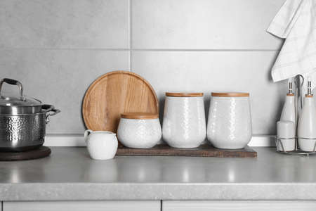 Different kitchenware and containers on gray countertop