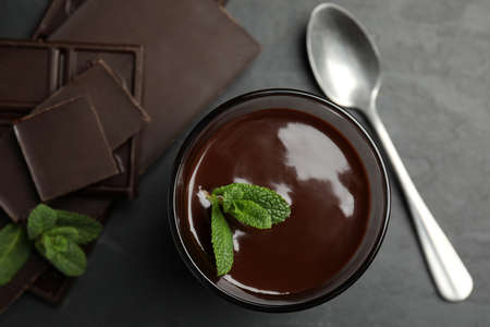 Glass of delicious hot chocolate with mint on dark gray table, flat layの写真素材