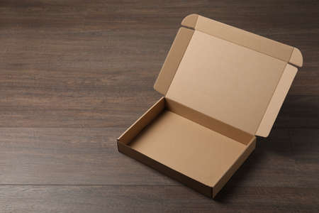 Empty open cardboard box on wooden table. Space for textの写真素材