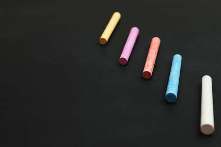 Colorful chalks on black board, space for textの写真素材