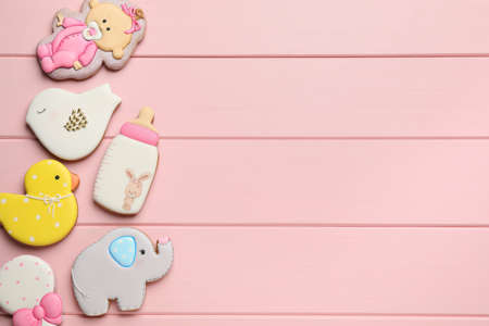 Cute tasty cookies of different shapes and space for text on pink wooden table, flat lay. baby...