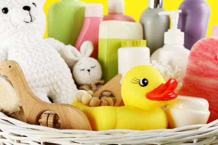 Different baby cosmetic products and accessories in wicker basket, closeup viewの写真素材