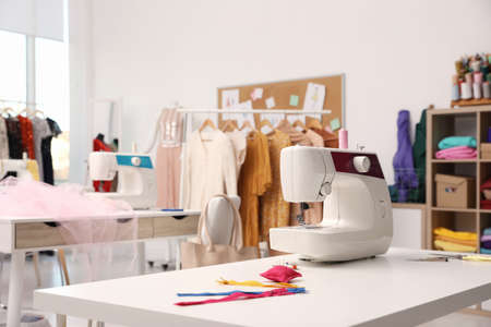 Sewing machine and accessories on table in dressmaking workshop