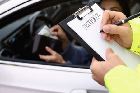 Woman trying to give bribe while police officer filling protocol, closeupの写真素材