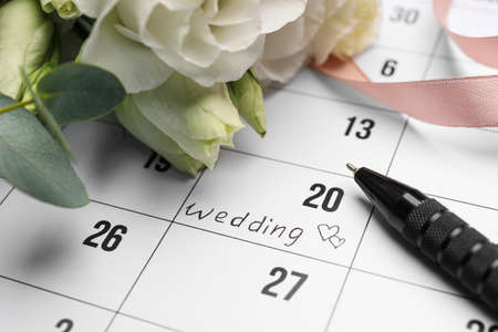 Calendar with date reminder about Wedding Day, pen and flowers, closeupの写真素材