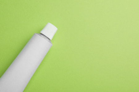 Blank white tube of ointment on light green background, top view. Space for textの写真素材