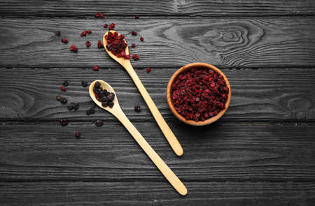 Dried black and red currant berries on wooden table, flat lay