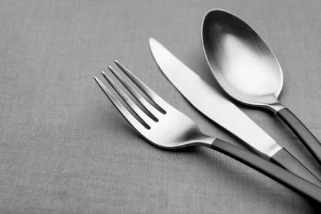 Set of shiny silver cutlery on gray table, closeup