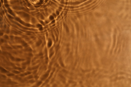 Close up view of water with circles on brown background