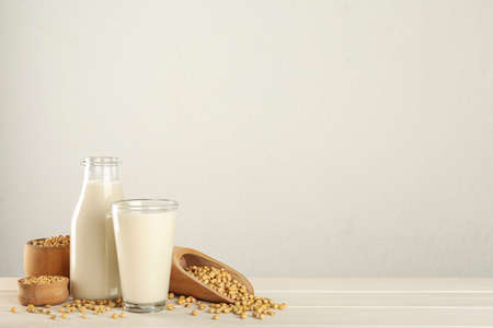 Fresh soy milk and grains on white wooden table. Space for textの写真素材