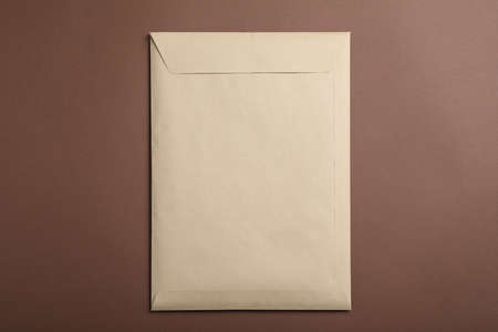 Kraft paper envelope on brown background, top viewの写真素材