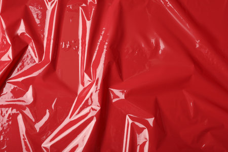 Red plastic stretch wrap as background, top view