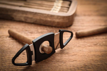 Cigars with guillotine cutter on wooden table