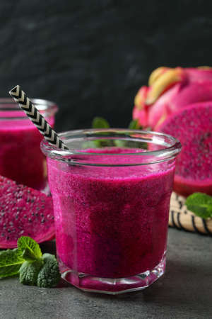 Delicious pitahaya smoothie, fruit and fresh mint on gray tableの写真素材