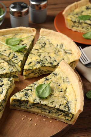 Cut delicious spinach pie on wooden board