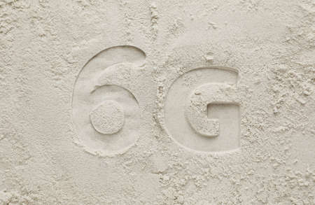 6G technology, Internet concept. Print of number and letter on white sand, flat layの写真素材