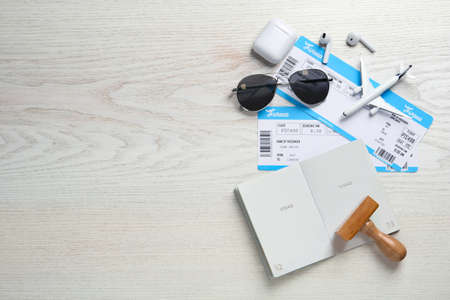 Flat lay composition with passport, stamp and flight tickets on white wooden table, space for textの写真素材