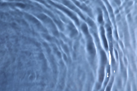 Close up view of water with rippled surface on blue background