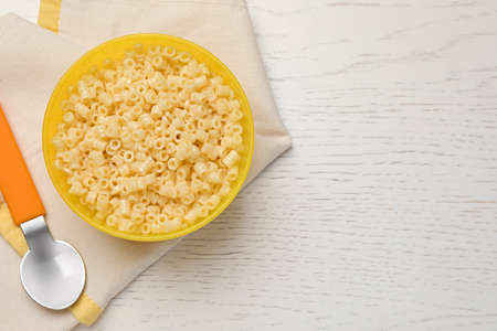 Bowl with tasty pasta on white wooden table, top view. Space for textの写真素材