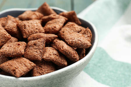 Bowl of sweet crispy corn pads on kitchen towel, closeup. breakfast cereal