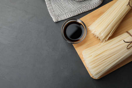 Dried rice noodles with soy sauce on black table, top view. Space for textの写真素材