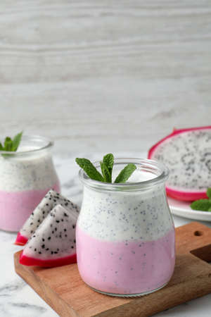 Delicious pitahaya smoothie, fruits and fresh mint on white marble tableの写真素材