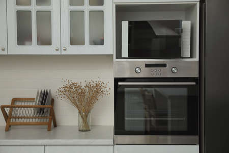 Modern microwave oven on shelf in kitchenの写真素材