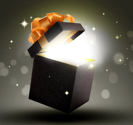 Beautiful gift box with magic light on color backgroundの写真素材